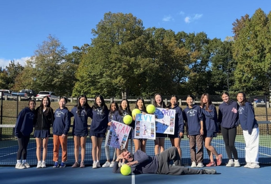 Senior Day Smiles on Tennis Courts—The girls varsity tennis team surprises Megan Chan, Ivy Zhang, and Gloria Lee on Senior Day with heartfelt posters and signed tennis balls before their match.

